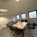 Innenansicht eines Büro- und Sozialraums der Gewerbeimmobilie mit Besprechungstisch und Fensterfront