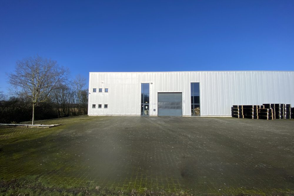 Außenansicht einer modernen Gewerbehalle mit großer befestigter Hoffläche zur Vermietung