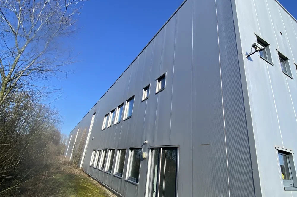 Fensterfront und separater Eingang des Bürotrakts einer Gewerbeimmobilie zur Vermietung